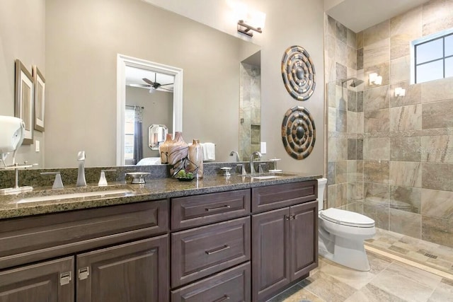 bathroom featuring vanity, ceiling fan, toilet, and tiled shower