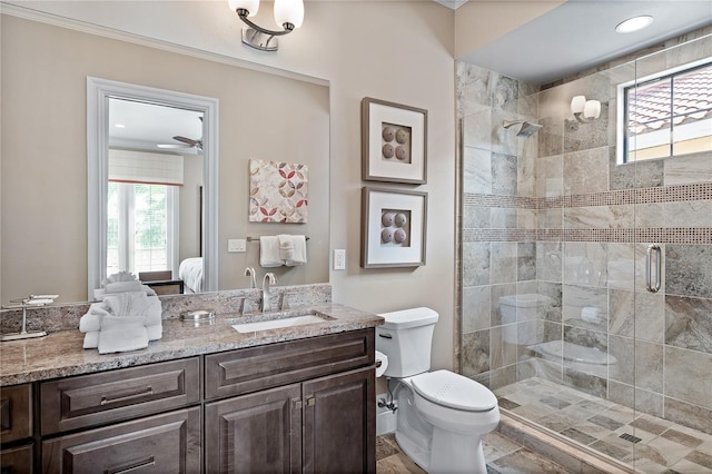 bathroom featuring vanity, toilet, ceiling fan, and a shower with shower door