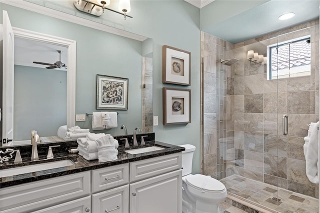 bathroom featuring vanity, a shower with door, crown molding, ceiling fan, and toilet