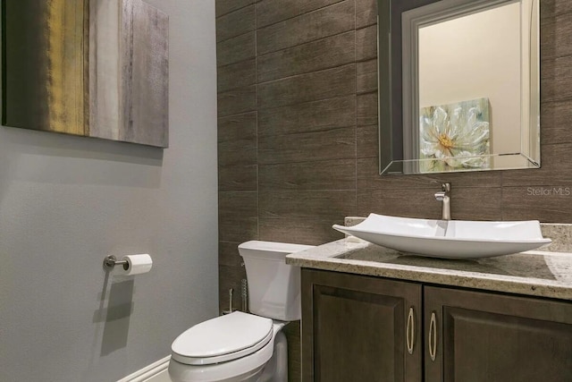 bathroom featuring vanity, tasteful backsplash, and toilet