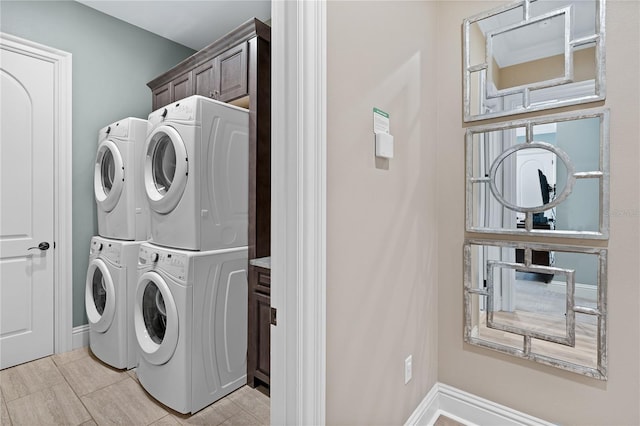 washroom with cabinets and stacked washer and dryer