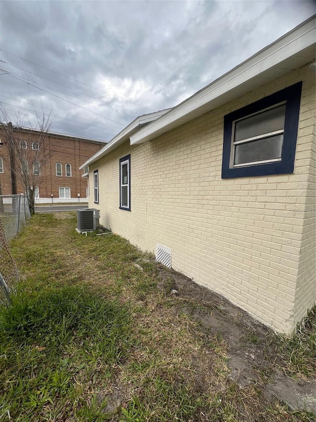 view of property exterior with a yard and central AC unit