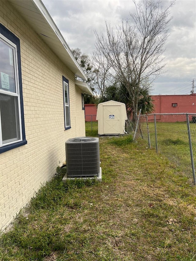 view of yard featuring central AC unit and a storage shed