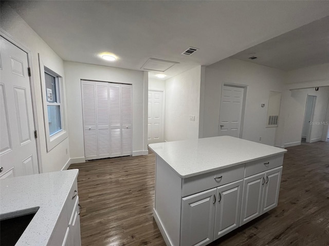 kitchen with white cabinets, dark hardwood / wood-style floors, a center island, and sink