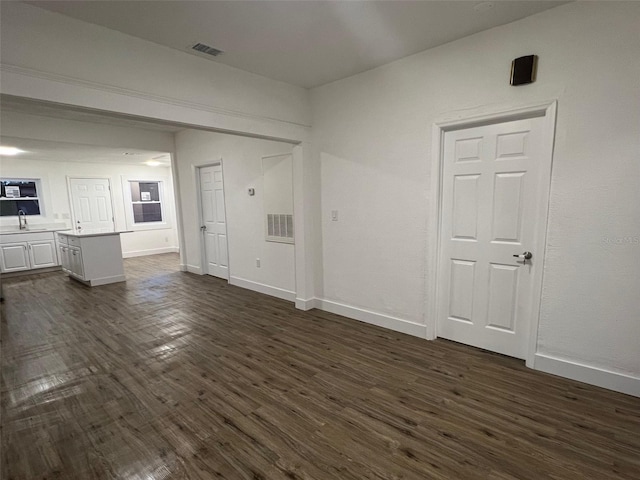 unfurnished living room with dark hardwood / wood-style floors and sink