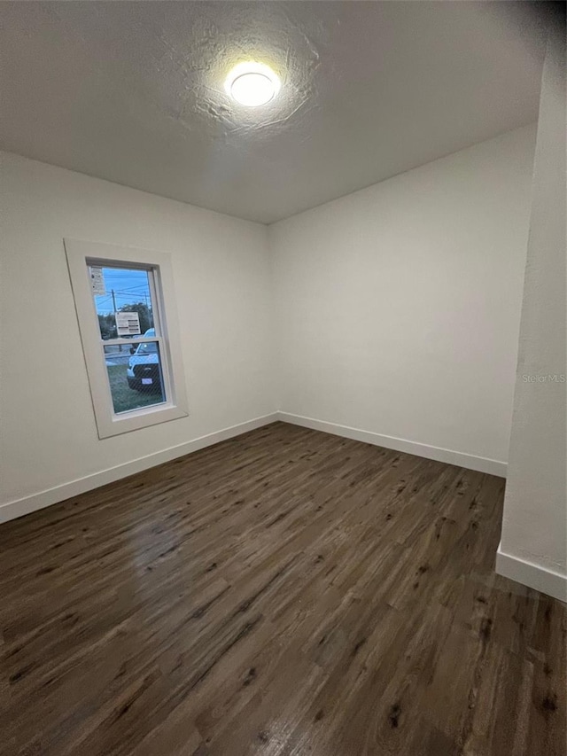 unfurnished room featuring a textured ceiling and dark wood-type flooring