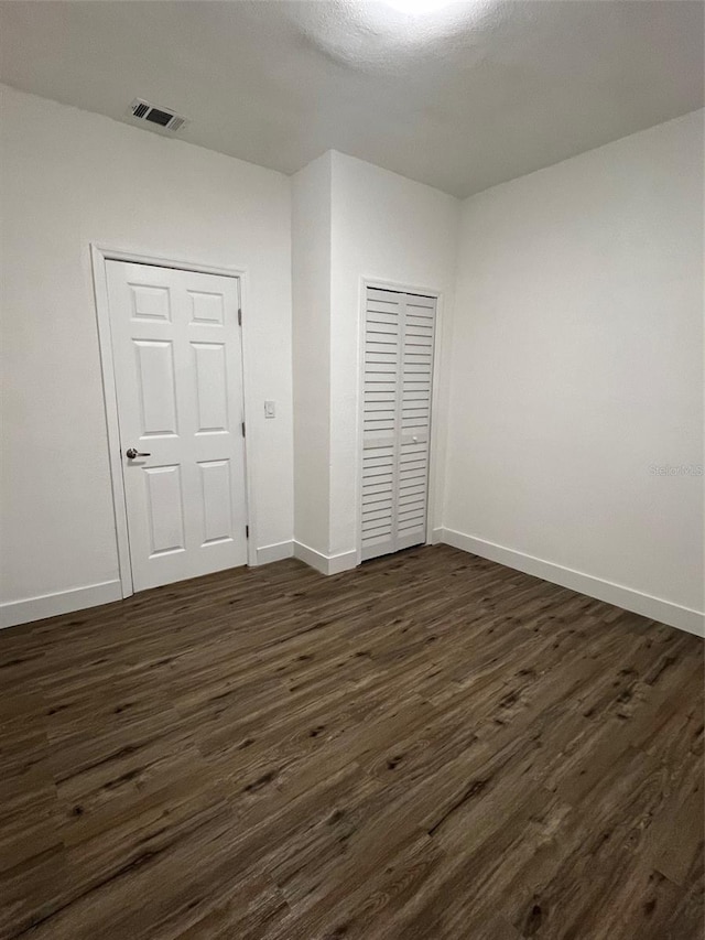 unfurnished bedroom with dark hardwood / wood-style floors