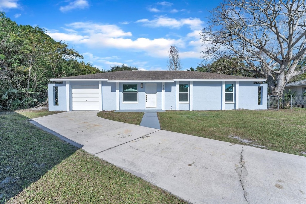 ranch-style home with a garage and a front lawn