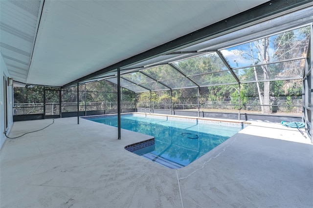 view of swimming pool with glass enclosure and a patio area