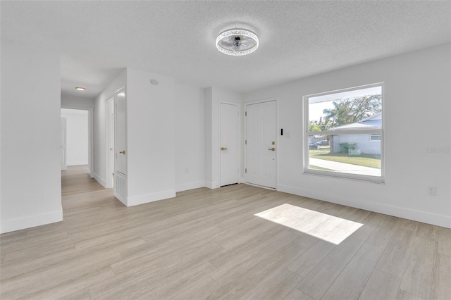 foyer entrance featuring light wood-type flooring and a textured ceiling