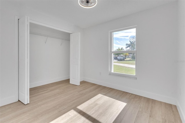 unfurnished bedroom featuring a closet and light hardwood / wood-style floors