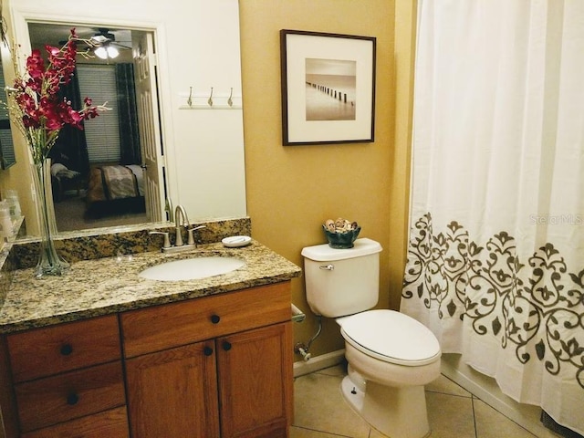 bathroom with tile patterned flooring, vanity, toilet, and ceiling fan