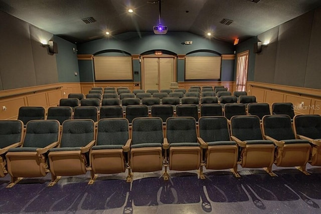 home theater with carpet floors and vaulted ceiling