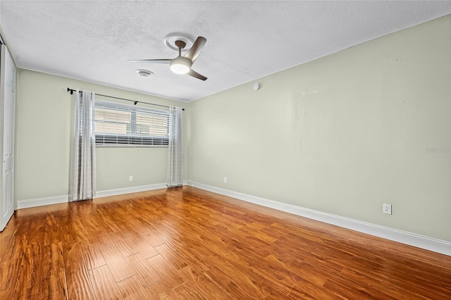 spare room featuring a textured ceiling, hardwood / wood-style flooring, and ceiling fan