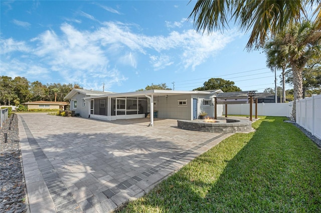 back of property with a sunroom and a yard