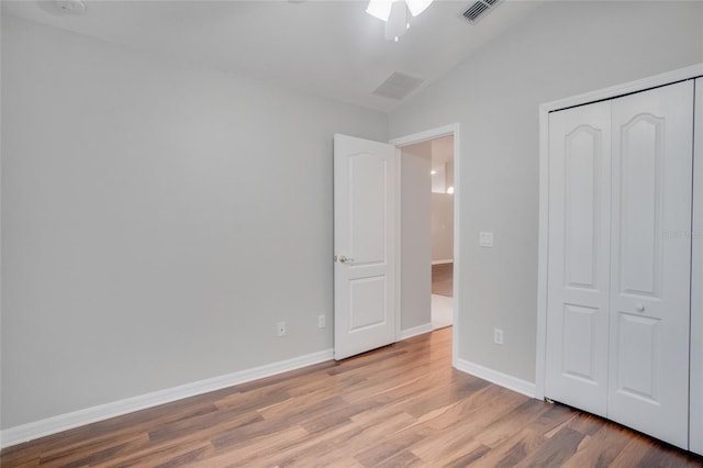 unfurnished bedroom featuring vaulted ceiling, ceiling fan, light hardwood / wood-style floors, and a closet