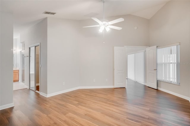 unfurnished room with lofted ceiling, ceiling fan, and light wood-type flooring