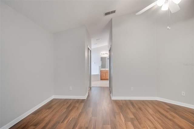 spare room with wood-type flooring, lofted ceiling, and ceiling fan