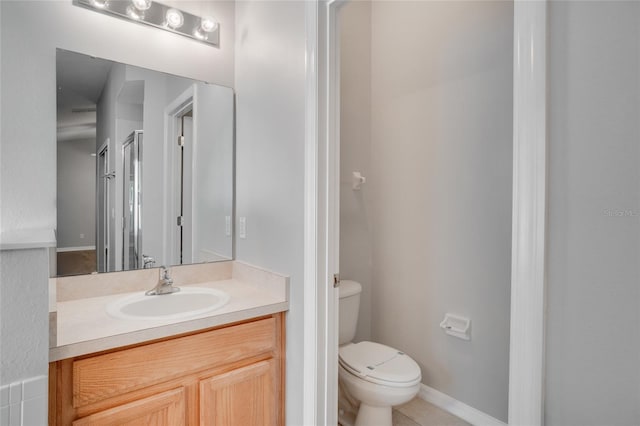 bathroom with tile patterned floors, vanity, toilet, and a shower with door