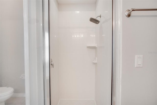 bathroom with walk in shower, toilet, and tile patterned flooring