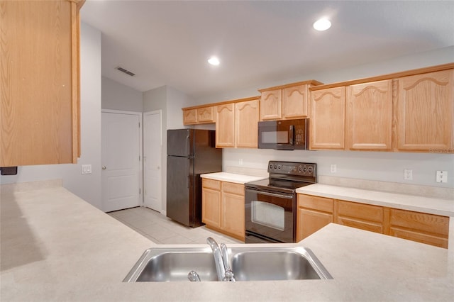 kitchen with lofted ceiling, light brown cabinetry, sink, and black appliances