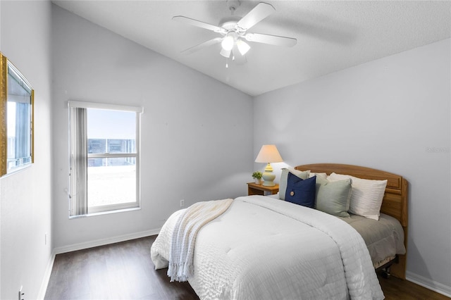 bedroom featuring ceiling fan, dark wood-type flooring, and vaulted ceiling