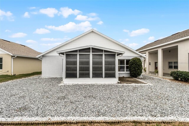 back of property with a sunroom