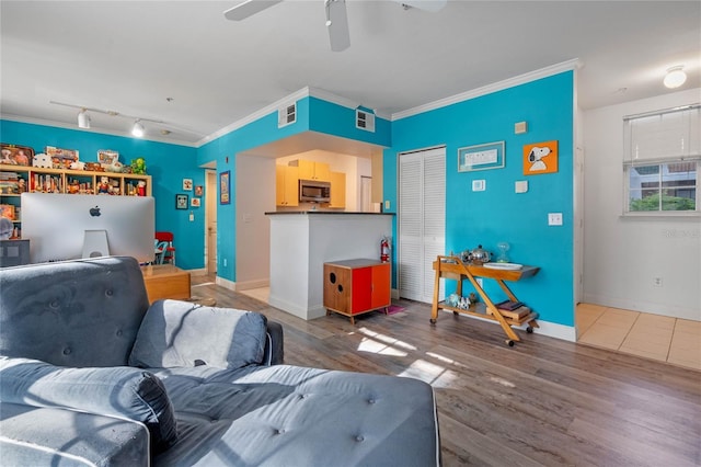 living room with ceiling fan, hardwood / wood-style floors, track lighting, and ornamental molding