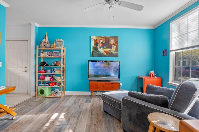 living area featuring crown molding, ceiling fan, and light hardwood / wood-style floors