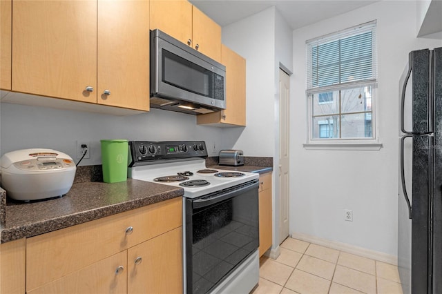 kitchen with black refrigerator, light tile patterned flooring, electric stove, and light brown cabinetry