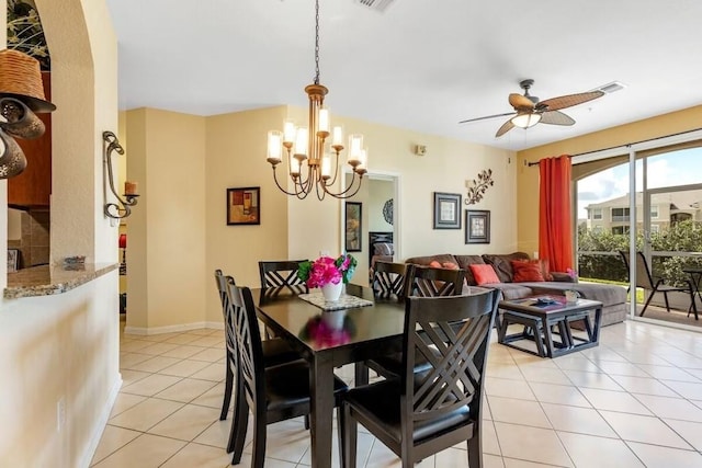 tiled dining space with ceiling fan with notable chandelier