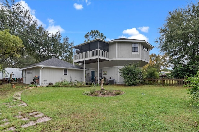 back of property with a sunroom, cooling unit, and a yard