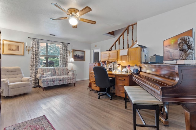 home office with ceiling fan, wood-type flooring, and a textured ceiling