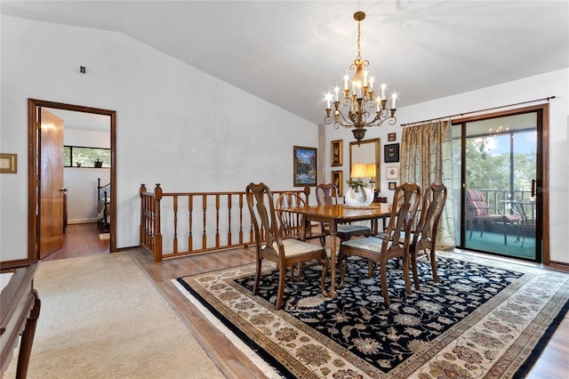 dining area with a notable chandelier, light hardwood / wood-style floors, and lofted ceiling