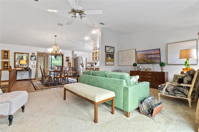 living room featuring ceiling fan with notable chandelier and lofted ceiling