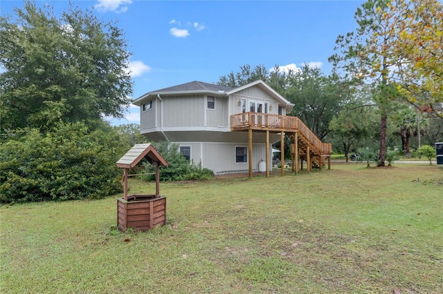 rear view of house with a wooden deck and a lawn