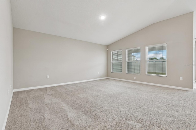 carpeted empty room featuring vaulted ceiling