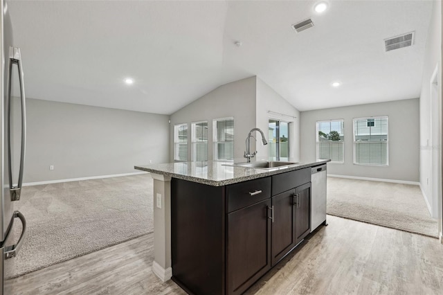 kitchen featuring dark brown cabinetry, sink, a kitchen island with sink, appliances with stainless steel finishes, and light wood-type flooring