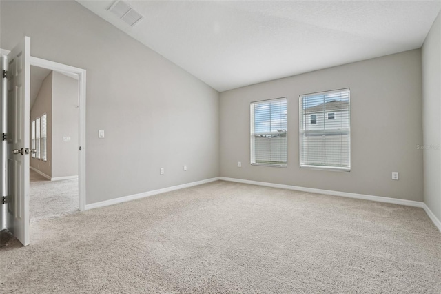 unfurnished room with light colored carpet and lofted ceiling