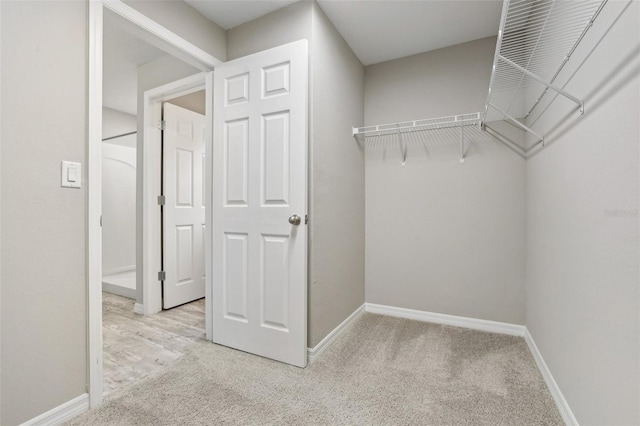 walk in closet featuring light carpet