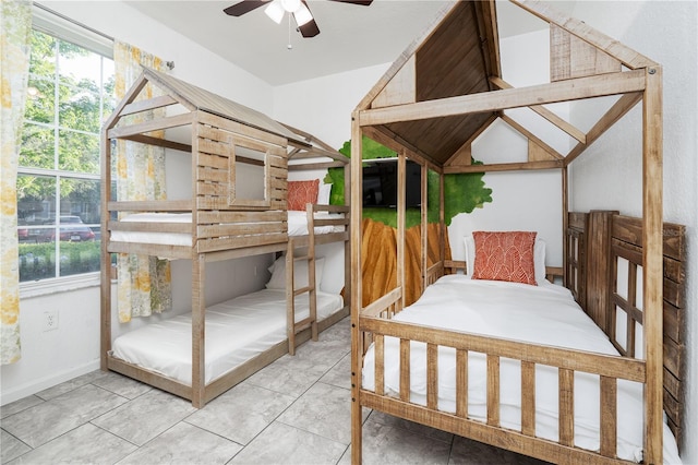 bedroom featuring tile patterned floors, ceiling fan, and multiple windows