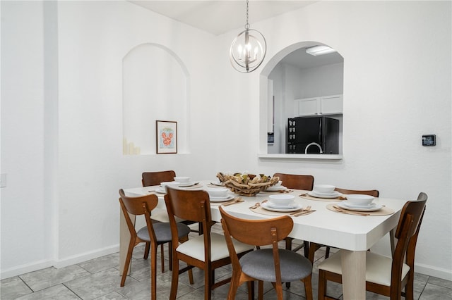 dining area with light tile patterned flooring and a chandelier