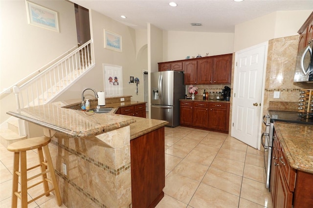 kitchen with an island with sink, stainless steel appliances, lofted ceiling, and sink