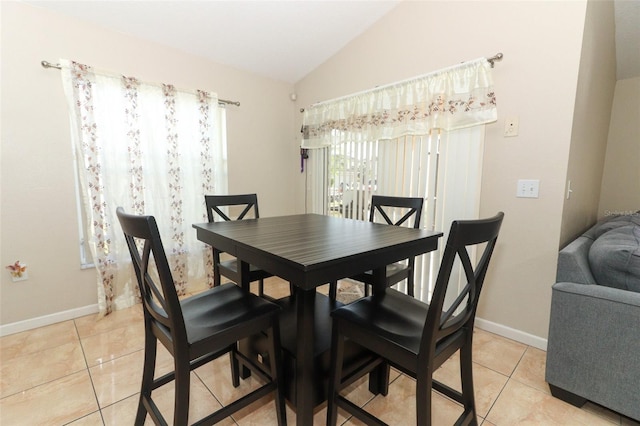 tiled dining room with vaulted ceiling