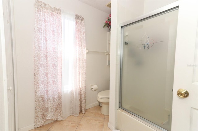 bathroom with shower / bath combination with glass door, tile patterned flooring, and toilet