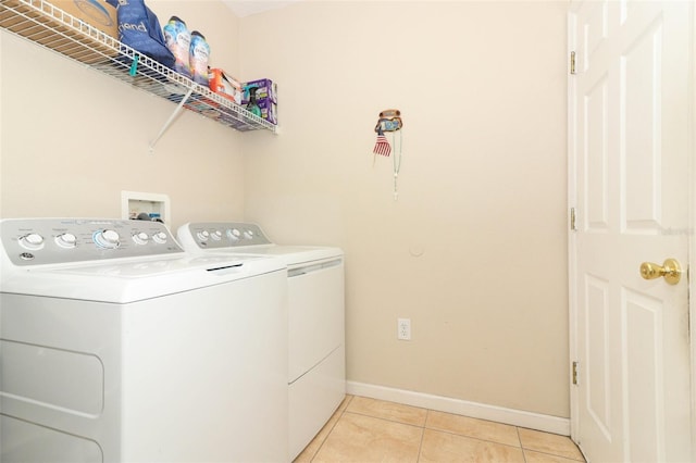 clothes washing area with light tile patterned floors and washing machine and clothes dryer