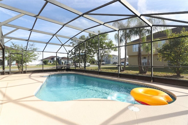 view of pool with a patio and glass enclosure