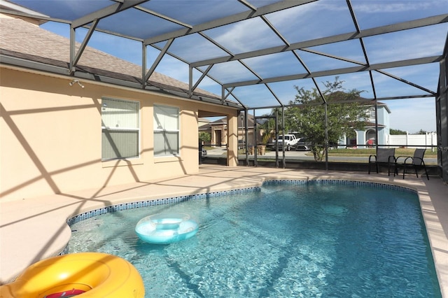 view of pool featuring glass enclosure and a patio area