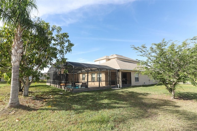 rear view of house featuring glass enclosure and a yard