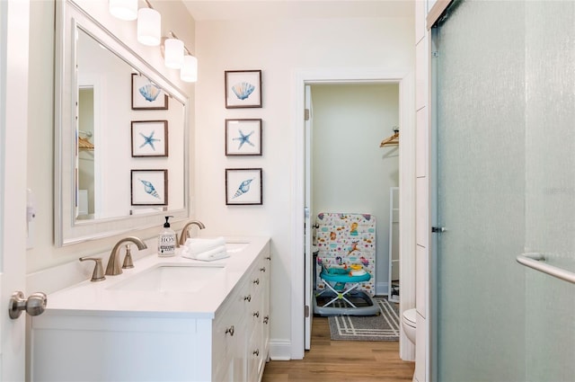 bathroom with vanity, toilet, a shower with door, and hardwood / wood-style floors